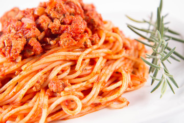 Spaghetti bolognese on a plate	 decorated with a rosemary twig