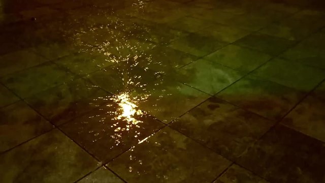 sparkling light reflection on rainwater and a shadow of a person. Close up-1