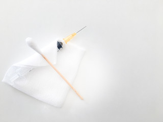 cotton bud or swab on gauze and syringe on white background for medical treament  concept with copy space