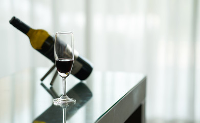 wine glass with blur bottle and cap on table in dramatic light