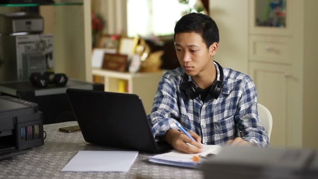 Teenage of Asian man study online at home through laptop, Online class concept.