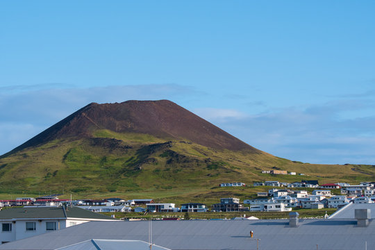 View over town of Heimaey and volcano Helgafell in Iceland on a sunny summer day