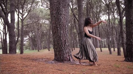 A Woman In Stylish Black Dress Doing A Grande Battement Inside The Centennial Park. -medium shot