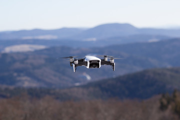 Flying drone at blue sky and mountains background
