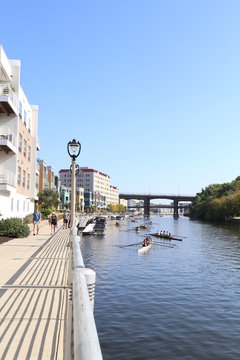 Riverwalk with rowers in water