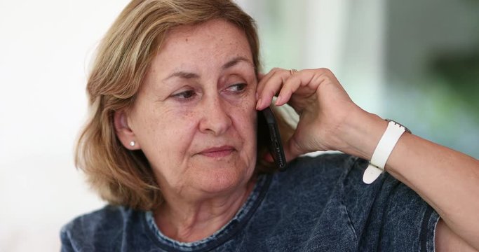 Older woman listening attentively on phone conversation