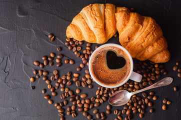 Coffee white cup, croissants on dark  background. Breakfast concept