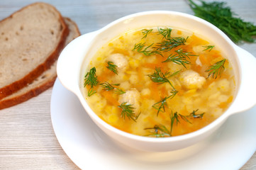 Chicken soup with meatballs and pasta on the table