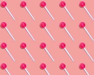 A pattern that shows candy on a stick, a pink Lollipop, on a light background