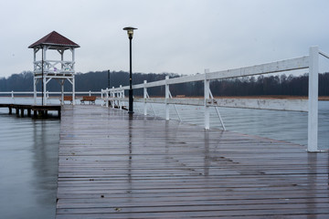 Wooden bridge on the water on a rainy day.