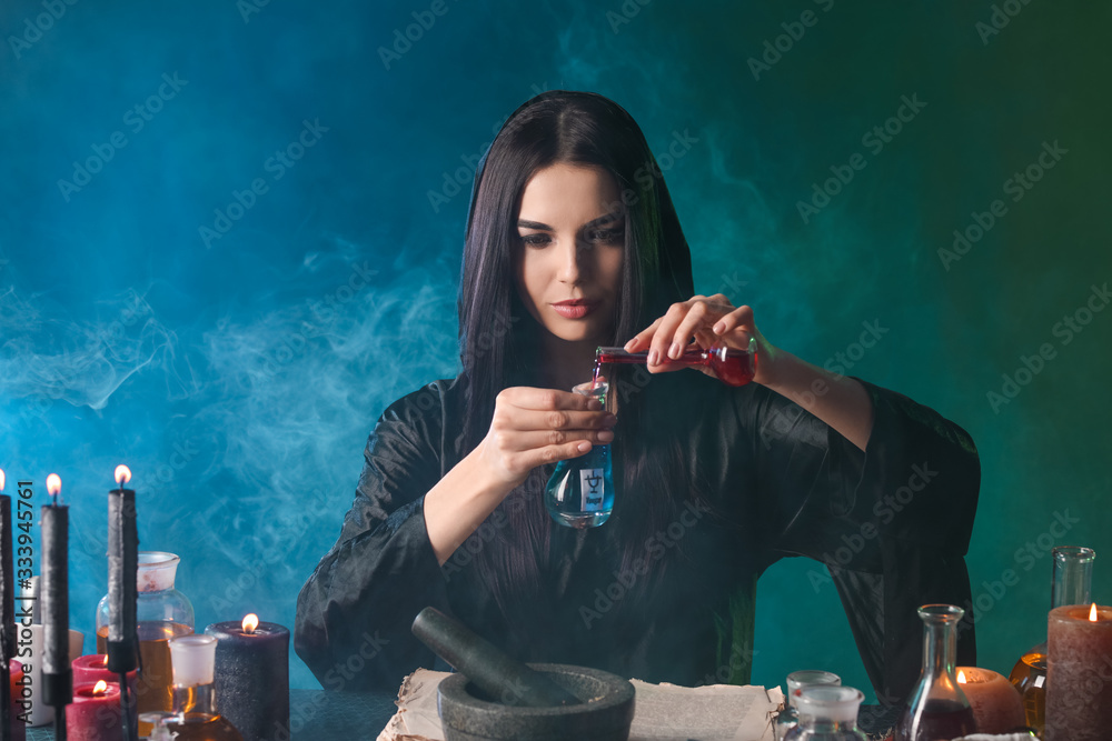 Wall mural female alchemist making potion on dark background