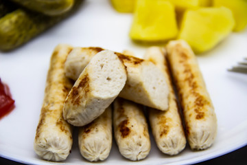 Delicious homemade chicken sausages boiled and made on the fire. Fragrant sausages made from non-GMO chicken. Toasted Mini Sausages from chicken on the plate