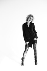 Fototapeta premium afro curls, blonde, emotions, fashion, red lipstick, jeans, white blouse, black jacket, black pantyhose