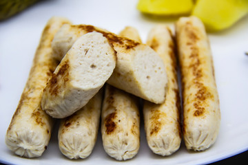 Delicious homemade chicken sausages boiled and made on the fire. Fragrant sausages made from non-GMO chicken. Toasted Mini Sausages from chicken on the plate