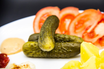 Fragrant cucumbers non-GMO on the plate with food. Ukrainian tasty food.