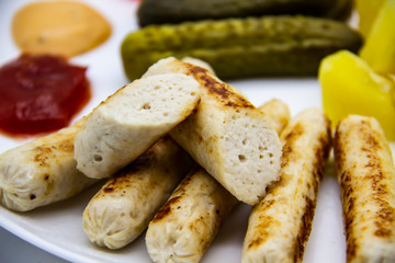 Delicious homemade chicken sausages boiled and made on the fire. Fragrant sausages made from non-GMO chicken. Toasted Mini Sausages from chicken on the plate