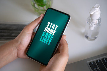 Stay home save lives for self quarine times. Hand holding mobile smart phone. Coronavirus or Covid-19  social media campaign concept, stay at home, social distancing for protect corona virus concept.