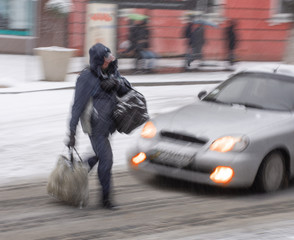 Busy city people on zebra crossing in motion blur. Winter snowy day, dangerous situation