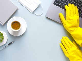 flat lay composition with laptop, gloves, coffee, notebook on blue background. Concept remote study and work at home, telework, freelance, quarantine. Distance online learning, disinfection. Copyspace