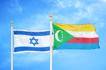 Israel and Comoros two flags on flagpoles and blue cloudy sky