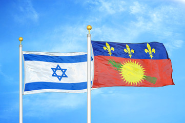Israel and Guadeloupe two flags on flagpoles and blue cloudy sky