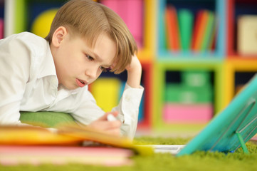 Portrait of cute little boy doing homework