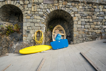 Medieval brick wall and yellow surfboard in  in Manarola town, Italy