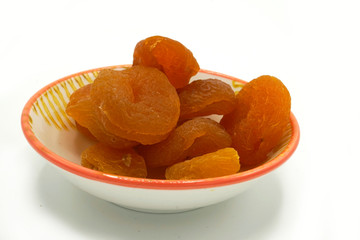 Dried apricots on a ceramic saucer isolated on white background. Energy and fiber natural source. Dieting food.