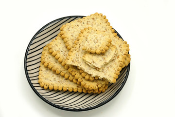 Dried fruits and digestive biscuits on a ceramic saucer isolated on white background. Energy and fiber natural source. Dieting food.