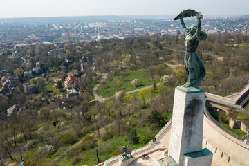 Obraz premium Empty tourist destination in Budapest, Hungary. People stay at home in self quarantine curfew, during the COVID-19 coronavirus. Liberty Statue, Citadella in abandoned view.