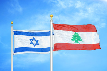 Israel and Lebanon two flags on flagpoles and blue cloudy sky