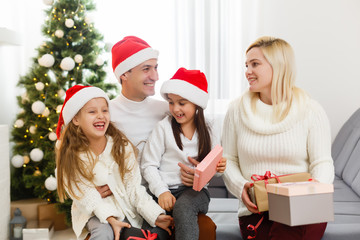 Portrait of friendly family looking at camera on Christmas evening