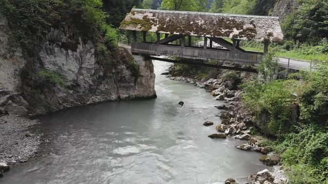 Cold mountain river with old bridge in Switzerland