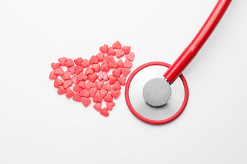 Heart made of pills and stethoscope on white background