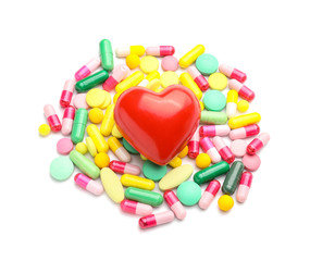 Red heart and pills on white background. Cardiology concept
