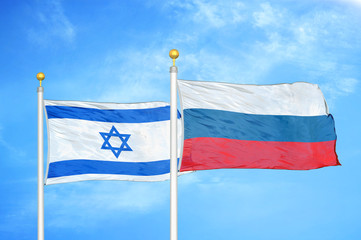 Israel and Russia two flags on flagpoles and blue cloudy sky