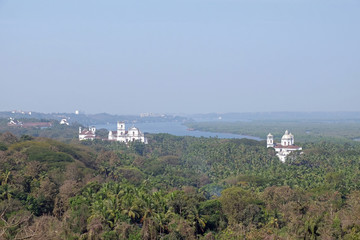 Fototapeta na wymiar Old Goa along Mandovi River with Se Cathedral in front of Church of St Francis of Assisi, left, and Church of St Cajetan, right, Goa, India