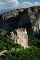 Monastery of Rousanou perched on a cliff in famous greek tourist destination Meteora in Greece on sunset with scenic landscape