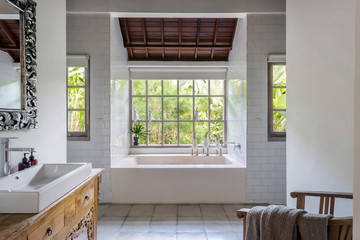 Cozy bright bathroom interior with built bathtub