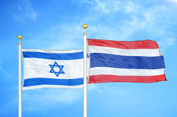 Israel and Thailand two flags on flagpoles and blue cloudy sky