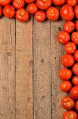 Fototapeta na wymiar Fresh tomato on wooden background. Top view with copyspace. Vertical photo.