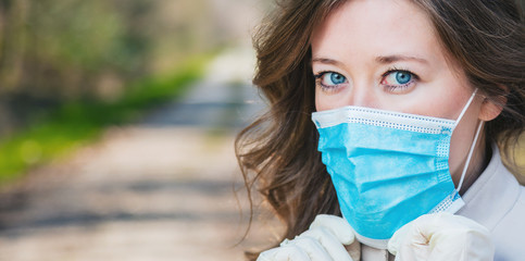 Frau mit Atemschutzmaske beim spaziergang im Park. Corona Virus Schutz.