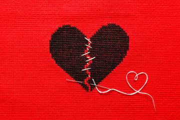 Black broken heart on red background. Embroidery.