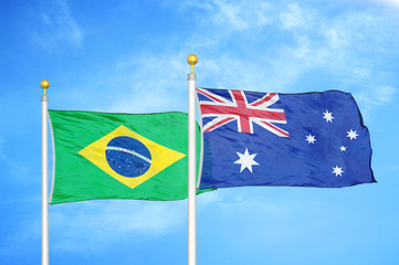 Brazil and Australia two flags on flagpoles and blue cloudy sky