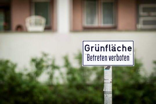 Schild mit Gr&uuml;nfl&auml;che betreten verboten vor einem Neubau