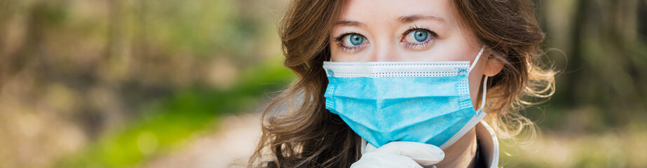Frau mit Atemschutzmaske beim spaziergang im Park. Corona Virus Schutz.