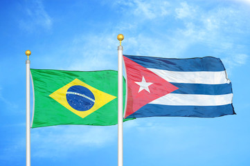 Brazil and Cuba two flags on flagpoles and blue cloudy sky