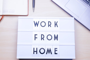 Workspace table with a lichtbox with the words WORK FROM HOME.