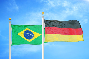 Brazil and Germany two flags on flagpoles and blue cloudy sky