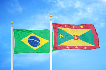 Brazil and Grenada two flags on flagpoles and blue cloudy sky